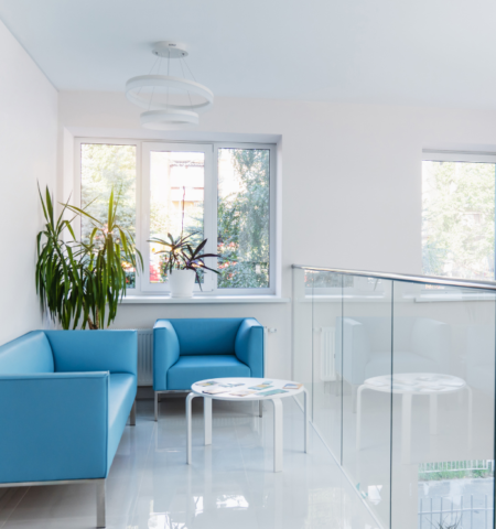 Ein moderner und heller Warteraum mit blauen Sesseln und Pflanzen im Inneren des IVF-Zentrums