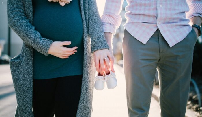 pregnant woman holds her husband